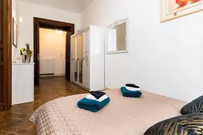 a bedroom with a bed with two blue pillows on it at Royal Center Palace in Prague