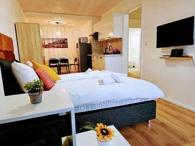 a large bed in a room with a kitchen at SUPERIOR PRAGUE 2BR APARTMENT for Business & Leisure, Private Garden, Free Parking & Gym, by LIVE-INN 1 in Prague