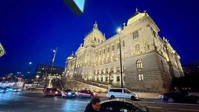 a large building with cars parked in front of it at Night at the Museum in Prague
