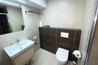 a bathroom with a white toilet and a sink at Apartment Mozart in Prague