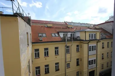 a city street with cars and a yellow van at Central cozy rooms Soukenická S32 in Prague
