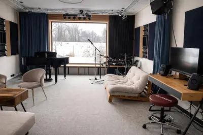 a living room with a piano and a television at Studio Big Win Mělník in Pšovka