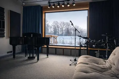 a living room with a piano and a room with a window at Studio Big Win Mělník in Pšovka