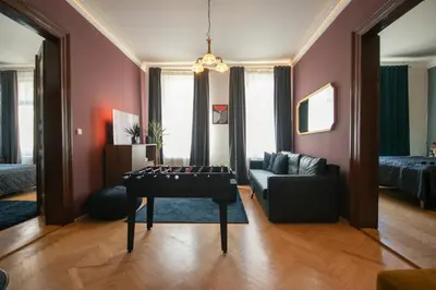 a living room with a table and a couch at Twin Residence Retro-Cinematic Apartment in City Centre in Prague