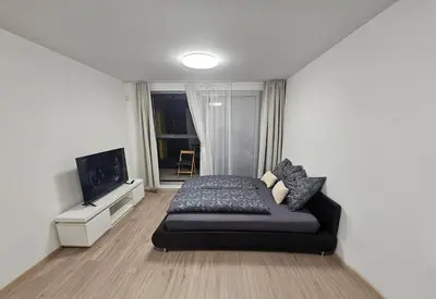 a bedroom with a bed and a flat screen tv at Centre NEW modern apartment & parking near O2 arena in Prague