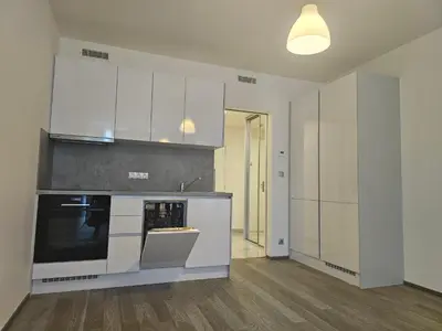 a kitchen with white cabinets and a stove top oven at Centre NEW modern apartment & parking near O2 arena in Prague