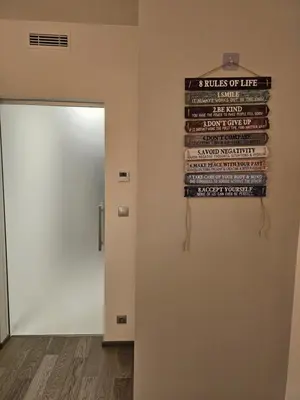 a sign hanging on a wall next to a door at Centre NEW modern apartment & parking near O2 arena in Prague