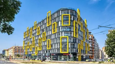 a yellow and gray building on a city street at Centre NEW stylish apartment & parking near O2 Arena in Prague