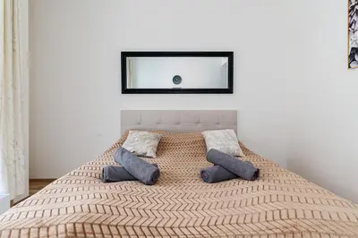 a bed with two pillows and a mirror on the wall at Bohemian Luxe Central in Prague