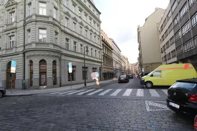a city street with cars and a yellow van at Central cozy rooms Soukenická S34 in Prague