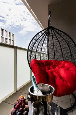 a balcony with a red couch and a bowl of fruit at New Bohemian Apartment in Prague