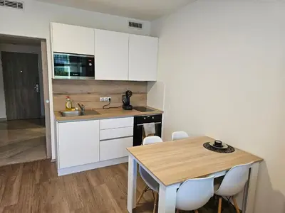 a kitchen with white cabinets and a wooden table at Centre Design Suite O2 Arena - Parking-Balcony-big TV-Coffee, 24 7 Self Check-in in Prague