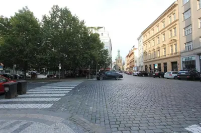 a cobblestone street in a city with cars and buildings at Central cozy rooms Soukenická S36 in Prague
