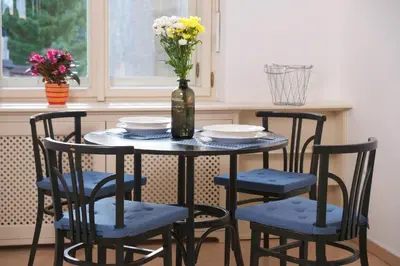a table with four chairs and a vase with flowers at Pawlansky Prague Apartments in Prague