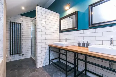 a bathroom with two sinks and two mirrors at Wishlist Prague Residences - Charles Bridge in Prague