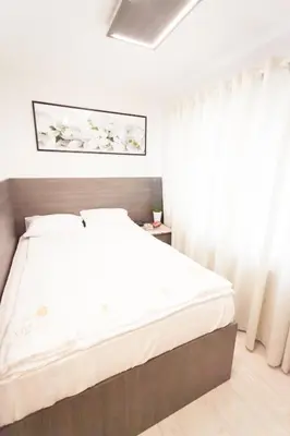 a bedroom with a large bed with white sheets at Villa Royal in Prague