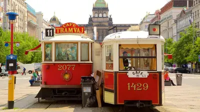 two trolley cars parked next to each other on a street at Stylish apartment a few steps from metro in Prague