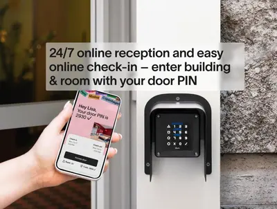 a person holding a cell phone in front of a door at Numa Prague Root in Prague