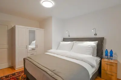 a bedroom with a bed with white pillows and a cabinet at Romantic Apartment Prague near Charles Bridge in Prague