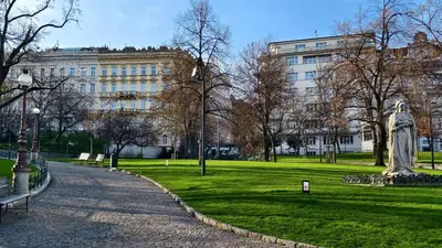 a statue in a park in front of a building at Apartment Kahoun in Prague