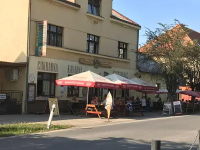 a building with tables and umbrellas in front of a building at Adela´s Czech Village House in Všejany