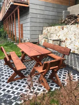 a wooden picnic table and benches on a patio at Chatka - C - Vyhlídka nad řekou in Zdiby