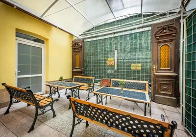 a group of tables and benches on a patio at Hotel Golden City Garni in Prague