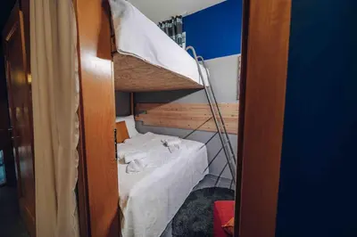 a small room with a bunk bed with a ladder at Unique apartment with private pool, cinema, SPA in Prague