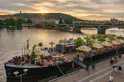 a boat on a river with a restaurant on it at Cozy Homestay at Prague Main Station in Prague
