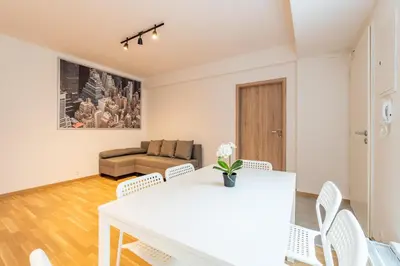 a living room with a white table and chairs at Brand new two room apartment #26 with free secure parking close to center in Prague