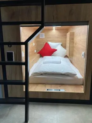 a bedroom with a bunk bed with a red pillow at Capsule hostel Žižkov tower in Prague
