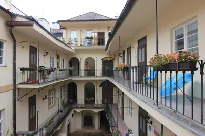 an alleyway between two buildings with flowerpots on balconies at 1 Bed Flat - Sleeps 3 - Courtyard - Wifi in Prague