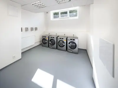 a laundry room with three washing machines in it at LUXURY APARTMENT VBLOKU in Prague