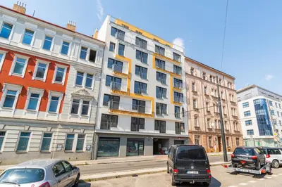 a large white building with cars parked in front of it at Brand new studio apartment #21 with free secure parking in the center in Prague